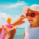 sun protection - mother put sunblock cream on little daughter face